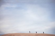 Vista à distância de três meninos andando na colina — Fotografia de Stock