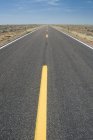 Strada vuota con linee gialle nel deserto, Arizona, Stati Uniti d'America — Foto stock