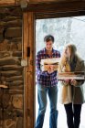 Couple carrying logs in rustic house — Stock Photo