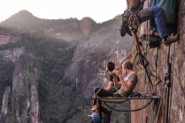 Due scalatori seduti su portaledge, guardando la vista, Liming, provincia dello Yunnan, Cina — Foto stock