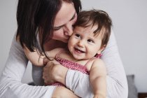 Portrait of mother hugging baby daughter — Stock Photo