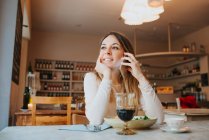 Frau telefoniert und lächelt im Restaurant weg — Stockfoto