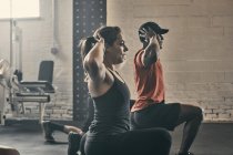 Les gens faisant de l'exercice dans la salle de gym, les mains derrière la tête — Photo de stock