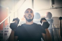 Man using dumbbells in gym — Stock Photo