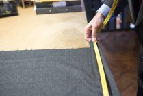 Tailor measuring cloth in tailor shop — Stock Photo