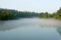 Vista panoramica del tranquillo lago nebbioso — Foto stock