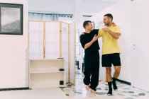 Freunde im Fitnessstudio mit Armen umeinander — Stockfoto