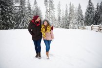 Молодая пара ходит по снегу — стоковое фото