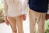 Безликие мужчина и женщина держатся за руки — стоковое фото