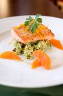 Salmon fillet with tangerine on white plate — Stock Photo