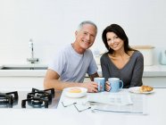 Älteres Paar beim Frühstück lächelt in die Kamera — Stockfoto