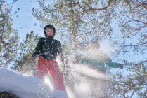 Двоє хлопчиків стрибають у снігу, з низьким кутом зору — стокове фото