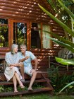 Couple assis sur les marches du porche et boire du vin dans le jardin — Photo de stock
