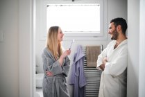 Casal jovem conversando e sorrindo no banheiro — Fotografia de Stock