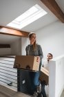 Couple portant des boîtes en carton à l'étage — Photo de stock