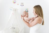 Mãe berço bebê no quarto de crianças — Fotografia de Stock