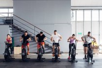 Люди в спортзале на велотренажерах — стоковое фото