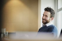 Empresário no escritório olhando para longe e sorrindo — Fotografia de Stock