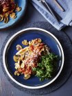 Stillleben mit Teller mit Truthahn, Pilzen, Parmesan und Grünkohlchips, Blick über den Kopf — Stockfoto