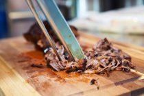 Pulled pork on wooden board, close-up — Stock Photo