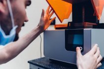 Мужчина-стоматолог с помощью 3D принтера — стоковое фото