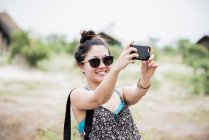 Молодая туристка делает селфи на смартфоне, Ботсвана, Африка — стоковое фото