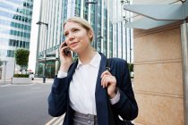 Молода бізнес-леді розмовляє по телефону в місті — стокове фото