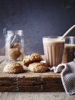 Still life of cardamom almond cookies and hot chocolate on cutting board — Stock Photo