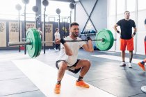 Mann beim Gewichtheben Langhantel in Turnhalle — Stockfoto
