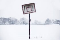 Разбитое баскетбольное кольцо на снежной площади — стоковое фото