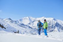 Padre e hijo en vacaciones de esquí con montañas de fondo, Hintertux, Tirol, Austria - foto de stock