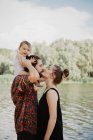 Casal com bebê menina beijando por lago, Toscana, Itália — Fotografia de Stock