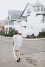 Woman in street holding bunch of balloons, Boston, Massachusetts, United States — Stock Photo