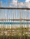 Vista de la cerca de madera en la playa - foto de stock