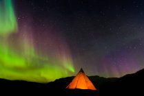 Lit up tent and Aurora Borealis in background, Narsaq, Vestgronland, Greenland — Stock Photo