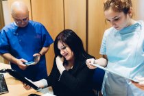 Zahnärztin und Zahnpflegerin mit Patient, Blick auf digitales Tablet — Stockfoto