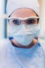 Ritratto di dentista donna, con maschera chirurgica e occhiali protettivi, primo piano — Foto stock