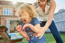 Mother and toddler daughter playing in garden — Stock Photo