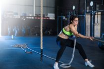Woman exercising in gymnasium, sled training — Stock Photo