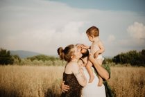 Paar mit Baby-Mädchen auf goldenem Grasfeld, Arezzo, Toskana, Italien — Stockfoto