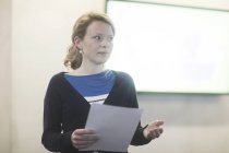 Женщина держит бумаги и делает презентацию — стоковое фото