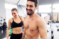 Pareja sonriendo en el gimnasio - foto de stock