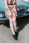 Обрезанный вид женщины, опирающейся на винтажный автомобиль — стоковое фото