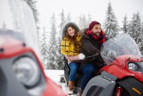 Jeune couple en motoneige en hiver — Photo de stock