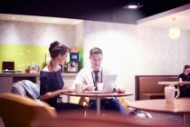 Empresário e mulher sentados no lounge do aeroporto, usando laptop — Fotografia de Stock