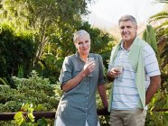 Couple mature buvant du vin dans le jardin — Photo de stock