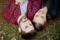 Overhead view of couple lying down on grass — Stock Photo