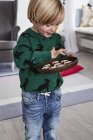 Jovem menino segurando prato de biscoitos — Fotografia de Stock