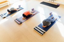 Drei Frauen üben Balasana (Kinderpose) im Yoga-Studio — Stockfoto