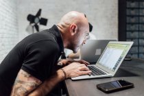 Man at desk peering in laptop in office — Stock Photo